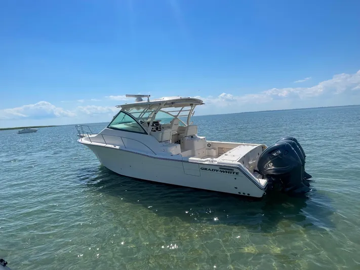  Yacht Photos Pics 2022 Grady-White Express 370 boat on clear water under a bright blue sky.