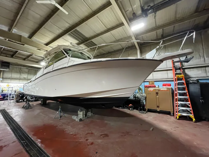  Yacht Photos Pics 2022 Grady-White Express 370 boat in a workshop, elevated on supports.