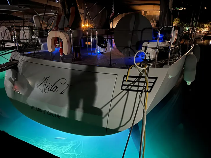 Aida II Yacht Photos Pics Sailboat CNB 66, 2018 model, docked at night with underwater lights illuminating water.