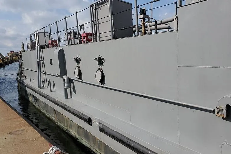  Yacht Photos Pics 1970 COMMERICAL BOAT LCU-135 docked at a harbor, side view.