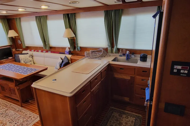 Nighthawk Yacht Photos Pics Luxurious 1999 Lyman-Morse pilothouse interior with elegant wood finishes and cozy seating area.