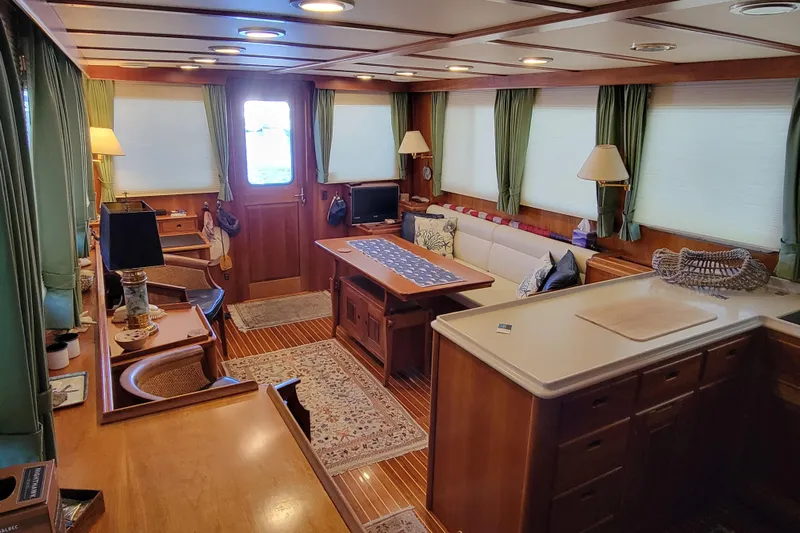Nighthawk Yacht Photos Pics Luxurious 1999 Lyman-Morse pilothouse interior with elegant wood finishes and cozy seating area.