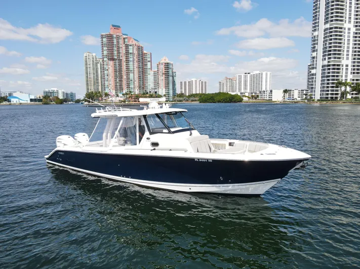  Yacht Photos Pics 2022 Pursuit S 358 Sport boat on water with city skyline background.