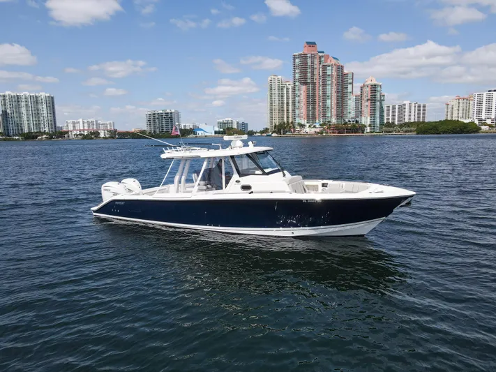  Yacht Photos Pics 2022 Pursuit S 358 Sport boat on water with city skyline background.