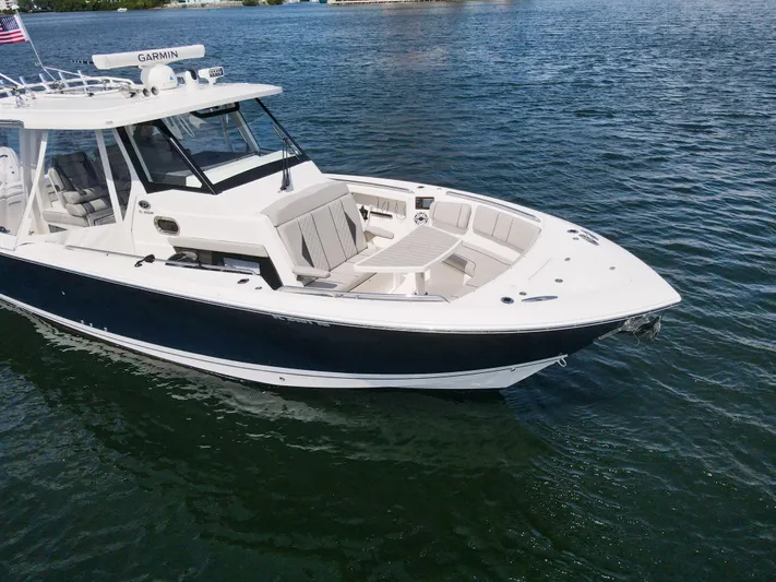  Yacht Photos Pics 2022 Pursuit S 358 Sport boat on calm water, featuring sleek design and spacious seating.