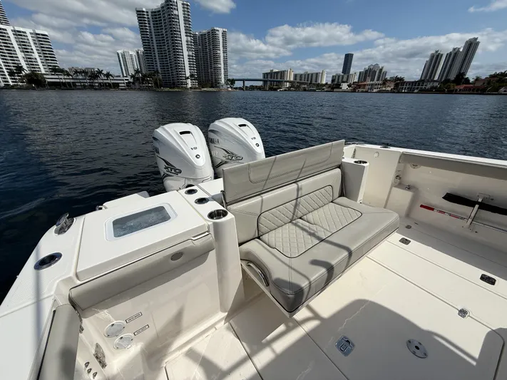  Yacht Photos Pics 2022 Pursuit S 358 Sport boat with twin engines, city skyline in background.