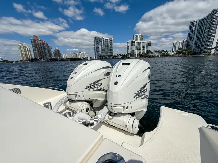  Yacht Photos Pics 2022 Pursuit S 358 Sport boat with Yamaha engines, city skyline in background.