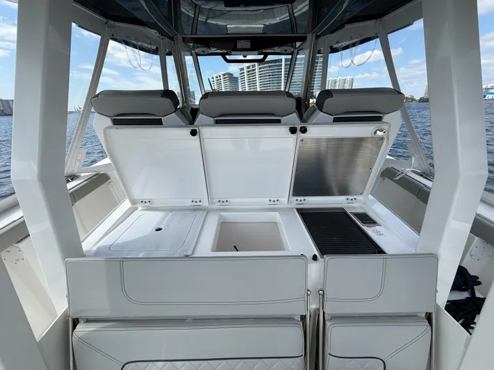  Yacht Photos Pics 2022 Pursuit S 358 Sport boat interior with open storage compartments and seating.