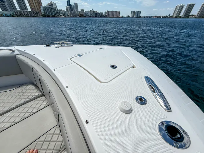  Yacht Photos Pics 2022 Pursuit S 358 Sport boat on water, city skyline in background.