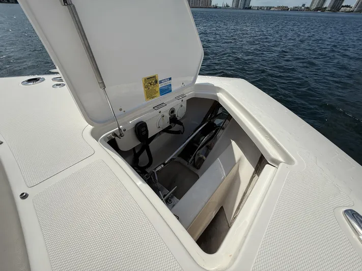  Yacht Photos Pics 2022 Pursuit S 358 Sport boat storage compartment open by the water.