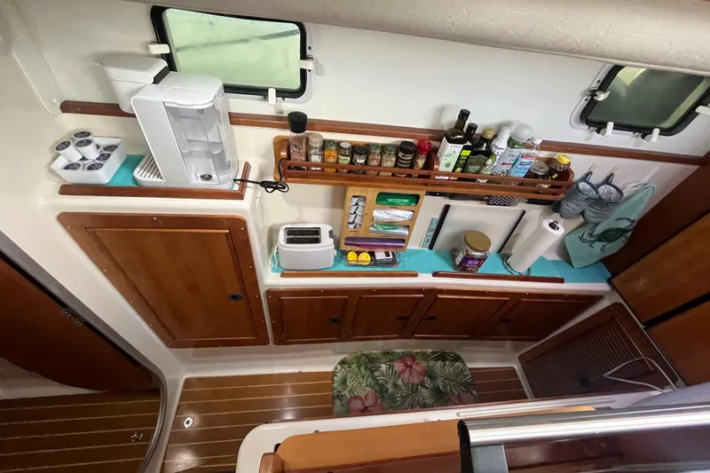  Yacht Photos Pics 2004 PDQ Passage Maker galley with wooden cabinets, appliances, and organized spices.