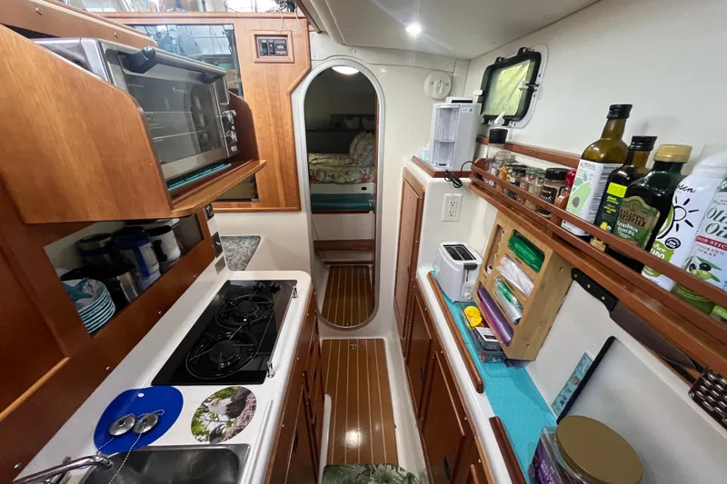  Yacht Photos Pics Compact kitchen in a 2004 PDQ Passage Maker boat, featuring appliances and storage.