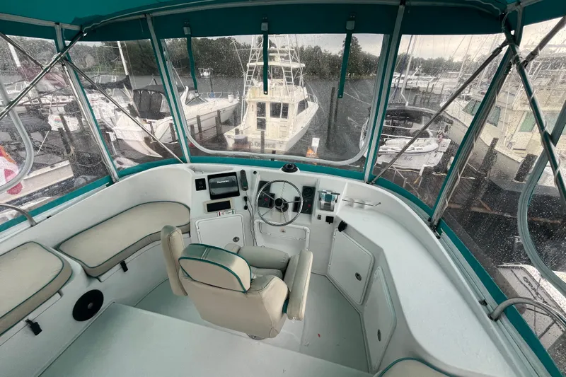  Yacht Photos Pics Helm of 2004 PDQ Passage Maker boat with rain-covered windows and marina view.