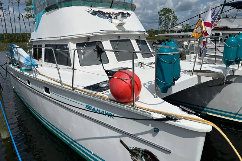  Yacht Photos Pics 2004 PDQ Passage Maker boat "Seahawk" docked, featuring vibrant decals and nautical flags.