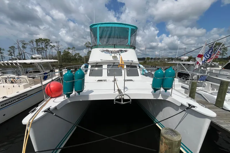  Yacht Photos Pics 2004 PDQ Passage Maker catamaran docked, featuring teal canopy and marine equipment.