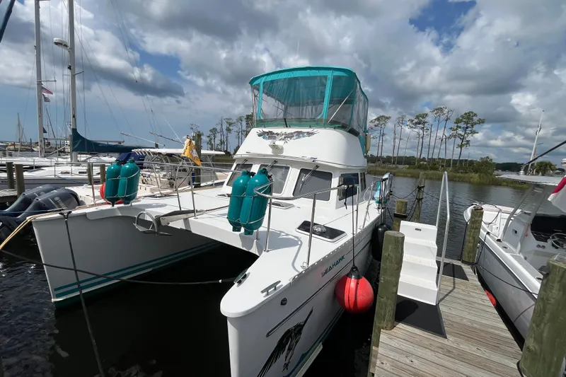  Yacht Photos Pics 2004 PDQ Passage Maker catamaran docked at marina under cloudy sky.