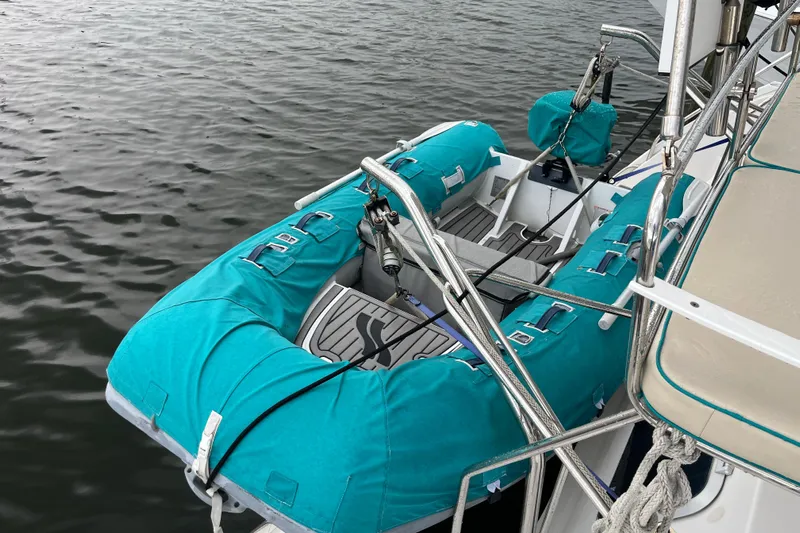  Yacht Photos Pics 2004 PDQ Passage Maker with turquoise inflatable dinghy on calm water.