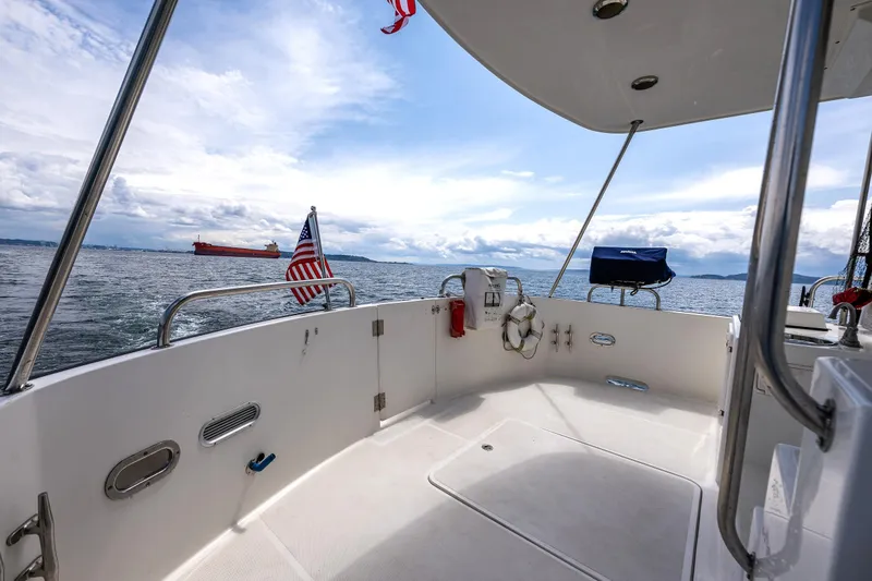 Speakeasy Yacht Photos Pics 2007 Nordic Tug 54 boat deck with ocean view and distant cargo ship.