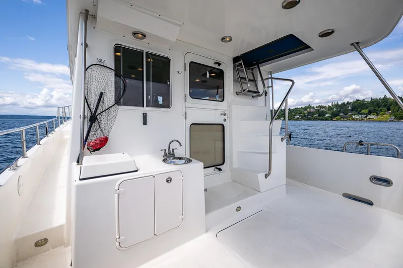 Speakeasy Yacht Photos Pics Nordic Tug 54 yacht deck, 2007 model, featuring outdoor sink and ladder, with scenic water view.