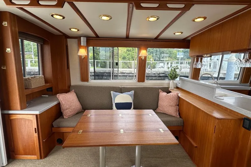 Speakeasy Yacht Photos Pics Cozy interior of 2007 Nordic Tug 54 with wooden dining area and large windows.