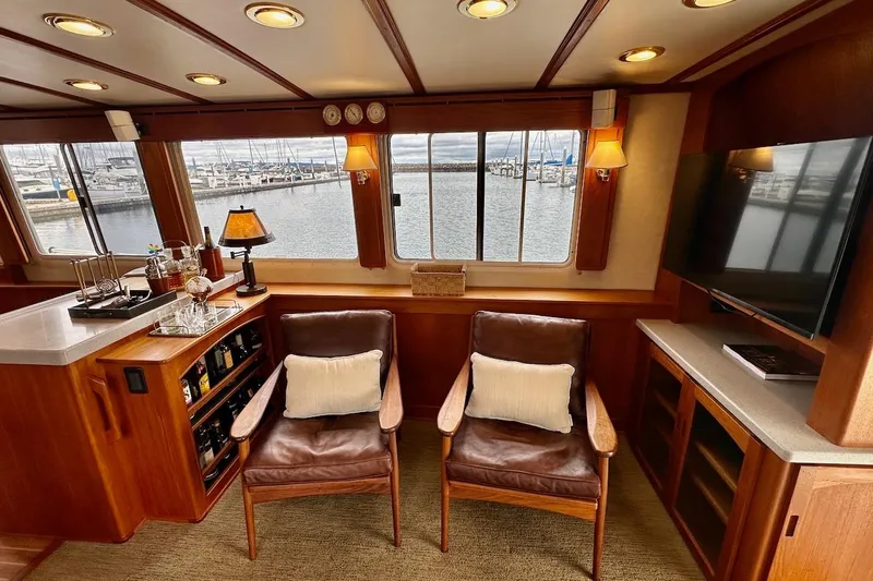 Speakeasy Yacht Photos Pics Luxurious interior of 2007 Nordic Tug 54 with leather chairs, bar, and marina view.