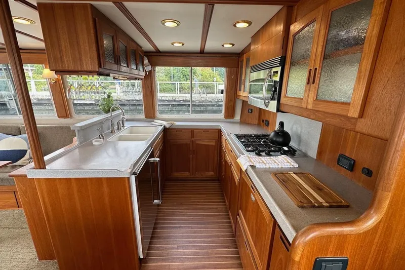 Speakeasy Yacht Photos Pics Luxurious 2007 Nordic Tug 54 kitchen with wood cabinetry, modern appliances, and large windows.