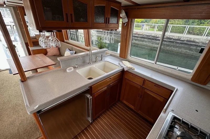 Speakeasy Yacht Photos Pics Luxurious 2007 Nordic Tug 54 galley with wooden cabinetry, dual sinks, and large windows.