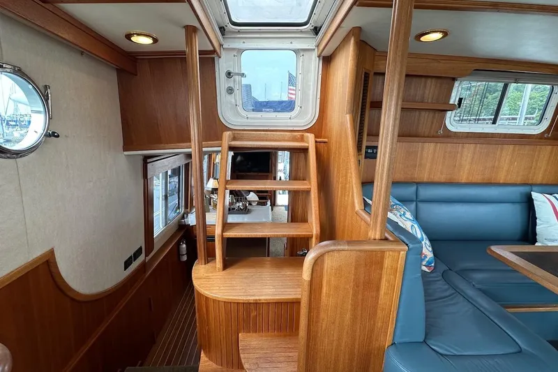 Speakeasy Yacht Photos Pics Interior of 2007 Nordic Tug 54, featuring wooden stairs and blue seating area.