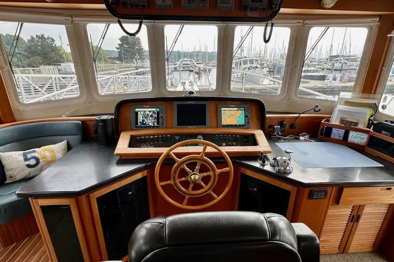 Speakeasy Yacht Photos Pics Pilothouse of 2007 Nordic Tug 54 with navigation equipment and marina view.