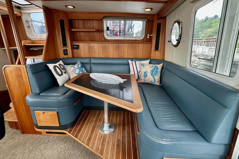 Speakeasy Yacht Photos Pics Luxurious 2007 Nordic Tug 54 interior with blue seating and wooden accents.