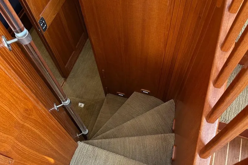 Speakeasy Yacht Photos Pics Staircase inside 2007 Nordic Tug 54 yacht, featuring wooden walls and carpeted steps.