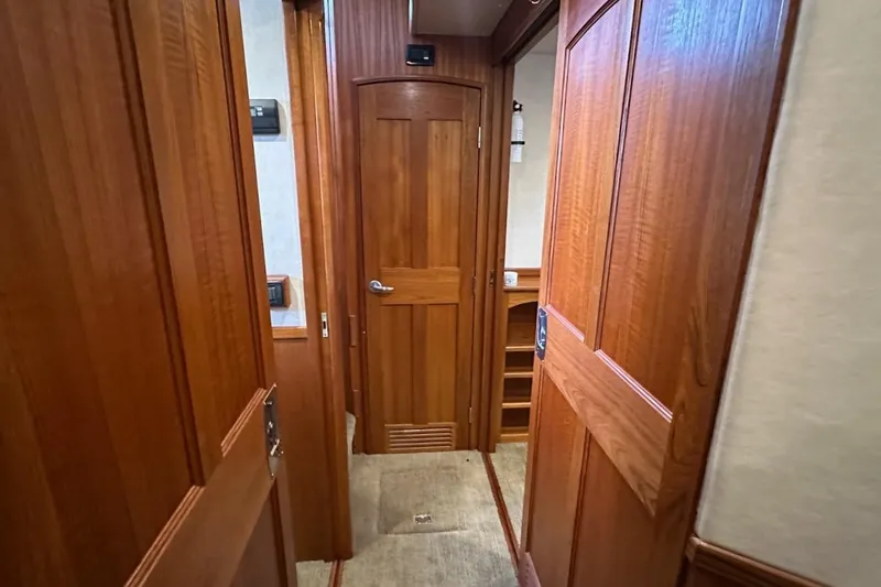 Speakeasy Yacht Photos Pics Interior hallway of 2007 Nordic Tug 54, featuring wooden doors and carpeted flooring.