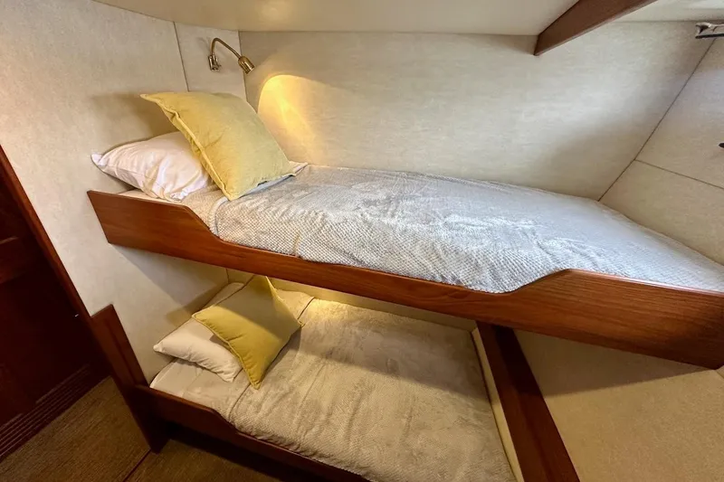 Speakeasy Yacht Photos Pics Bunk beds in a 2007 Nordic Tug 54, featuring cozy bedding and warm lighting.