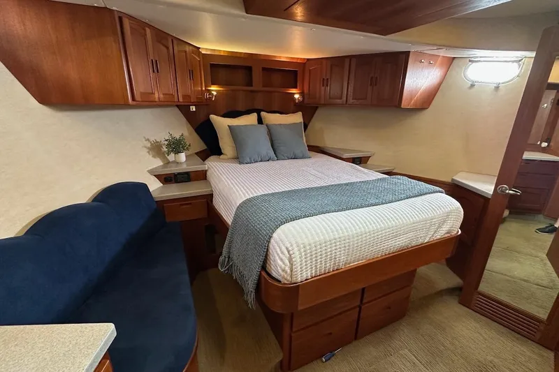 Speakeasy Yacht Photos Pics Luxurious 2007 Nordic Tug 54 bedroom with cozy bed, wooden cabinets, and elegant decor.
