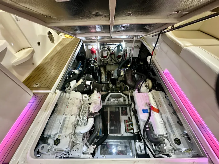 Sand Bar Yacht Photos Pics Engine compartment of 2011 Sea Ray 450 Sundancer with dual engines and pink accent lighting.
