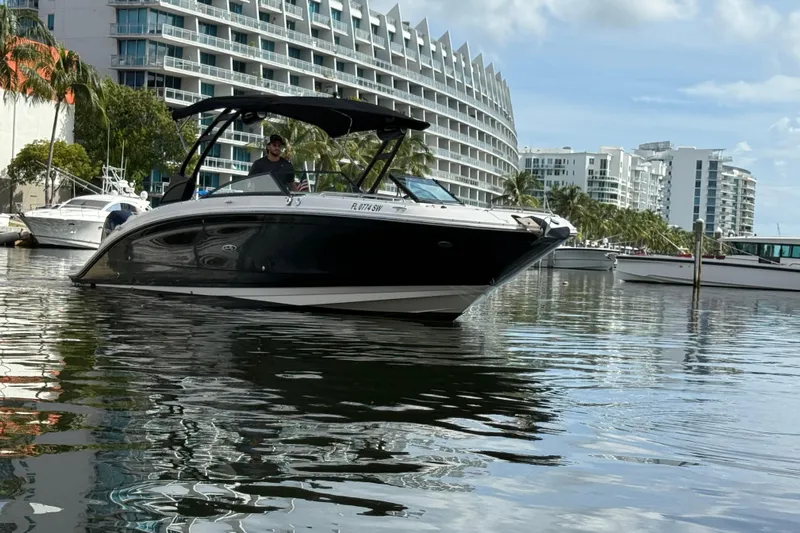  Yacht Photos Pics 2021 Sea Ray SDX 290 Outboard boat on water near modern buildings.