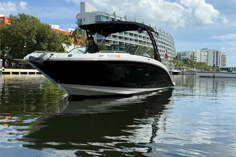  Yacht Photos Pics 2021 Sea Ray SDX 290 Outboard boat on water, modern buildings in background.