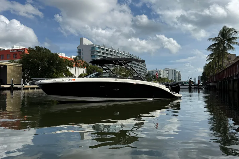  Yacht Photos Pics 2021 Sea Ray SDX 290 Outboard boat on a calm urban waterway.