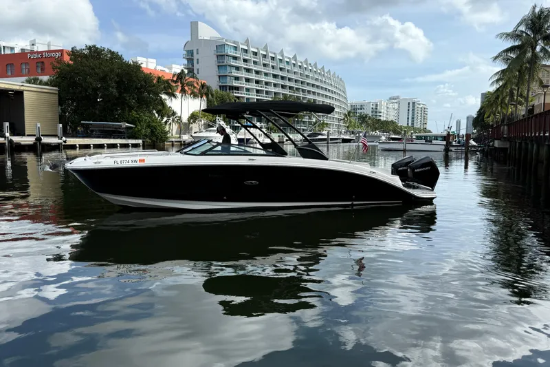 Yacht Photos Pics 2021 Sea Ray SDX 290 Outboard boat docked in a scenic urban marina.
