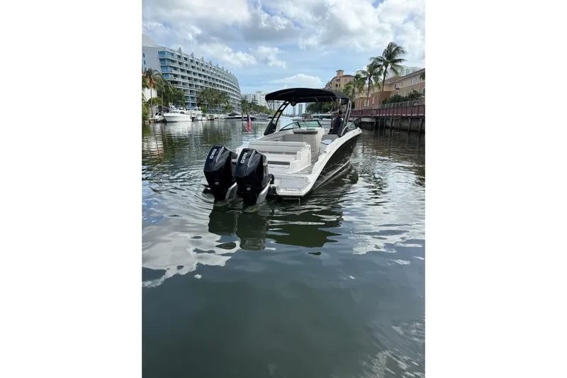  Yacht Photos Pics 2021 Sea Ray SDX 290 Outboard boat on calm water near waterfront buildings.