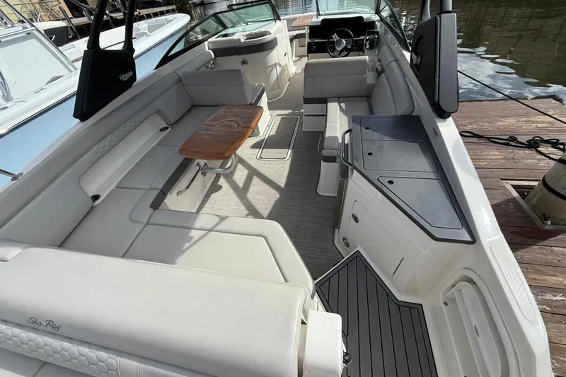  Yacht Photos Pics 2021 Sea Ray SDX 290 Outboard boat interior with seating and wooden table.