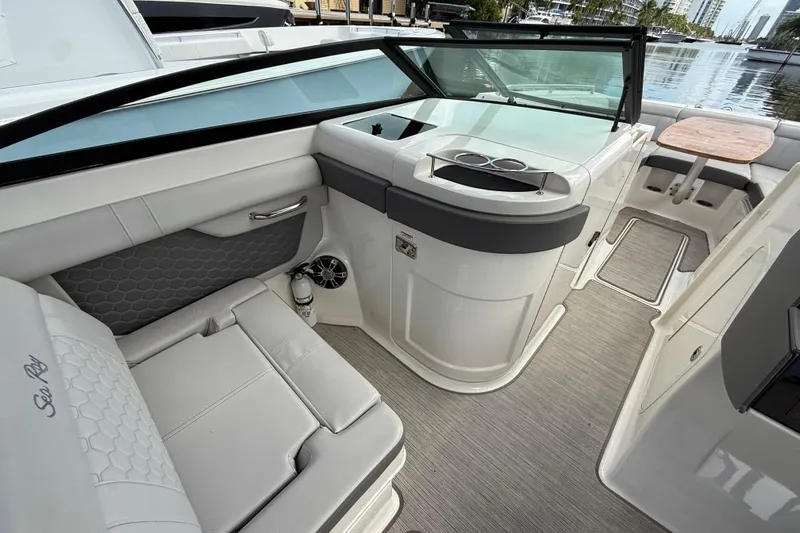  Yacht Photos Pics 2021 Sea Ray SDX 290 Outboard interior with seating and table, docked by the water.
