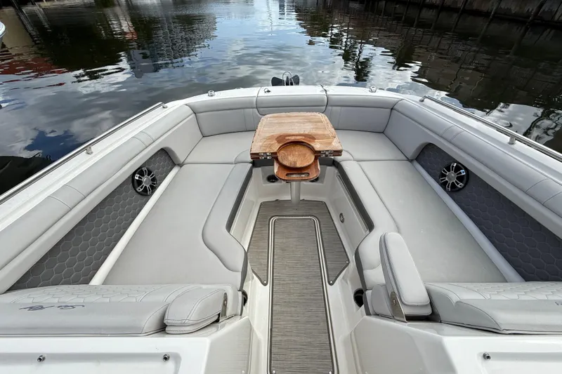  Yacht Photos Pics 2021 Sea Ray SDX 290 Outboard boat interior with seating and wooden table on calm water.
