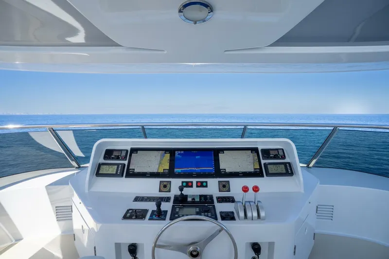 Ruffian Yacht Photos Pics Helm of 2001 Delta Marine Tri-Deck yacht with navigation screens, steering wheel, and ocean view.