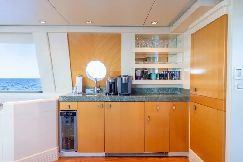 Ruffian Yacht Photos Pics Luxurious Delta Marine Tri-Deck yacht interior with modern kitchenette, ocean view, and elegant wood cabinetry.