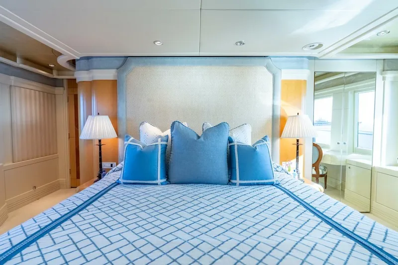 Ruffian Yacht Photos Pics Luxurious bedroom on 2001 Delta Marine Tri-Deck yacht with blue accents and elegant decor.