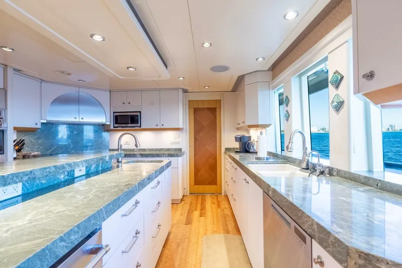 Ruffian Yacht Photos Pics Luxurious kitchen on 2001 Delta Marine Tri-Deck yacht with marble countertops and ocean view.