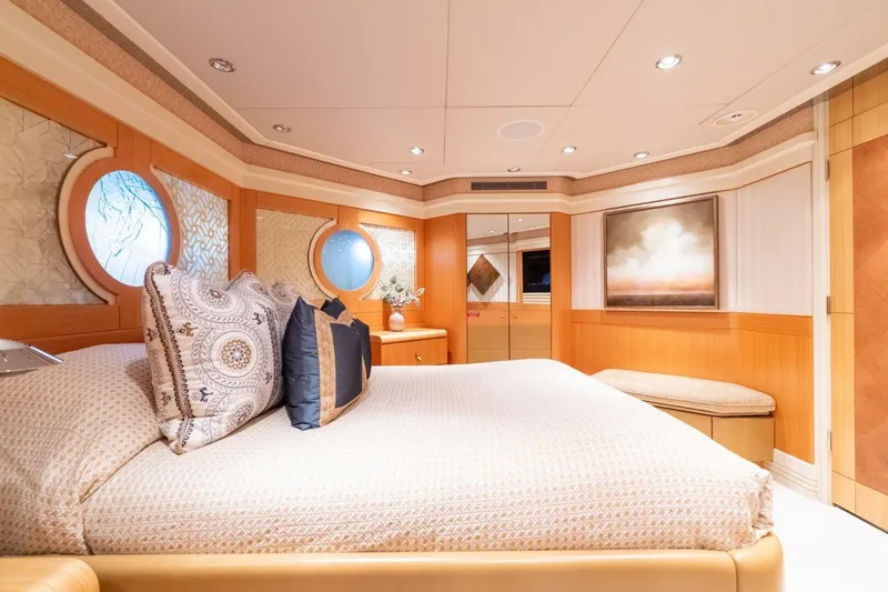 Ruffian Yacht Photos Pics Luxurious bedroom interior on 2001 Delta Marine Tri-Deck yacht, featuring elegant decor and porthole windows.