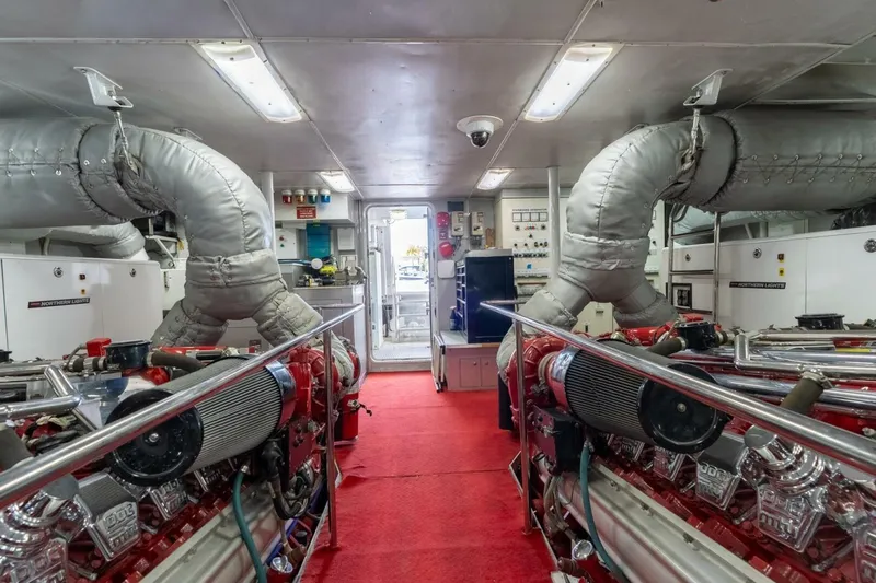 Ruffian Yacht Photos Pics Engine room of 2001 Delta Marine Tri-Deck yacht with red carpet and machinery.