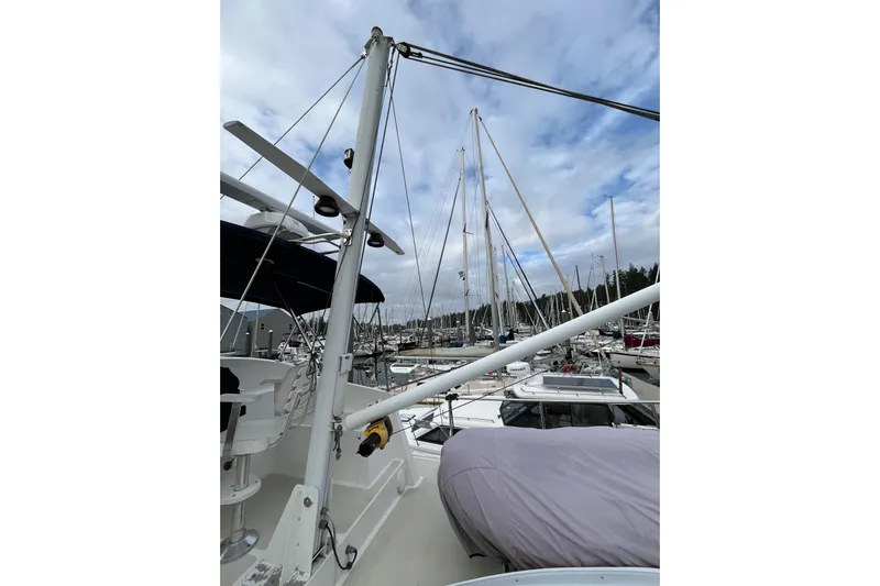 Abina Yacht Photos Pics 2001 Kadey-Krogen 39 yacht in marina, surrounded by sailboats under cloudy sky.